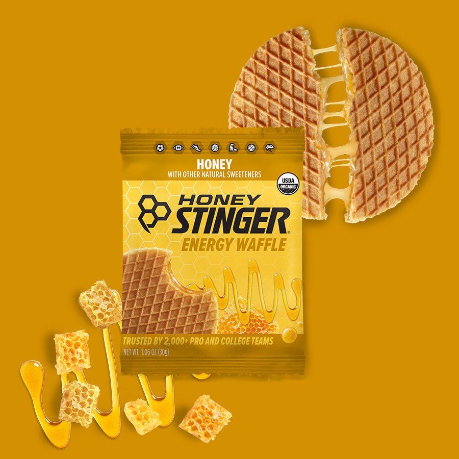 Honey Stinger energy waffle package with a waffle slice on a yellow background