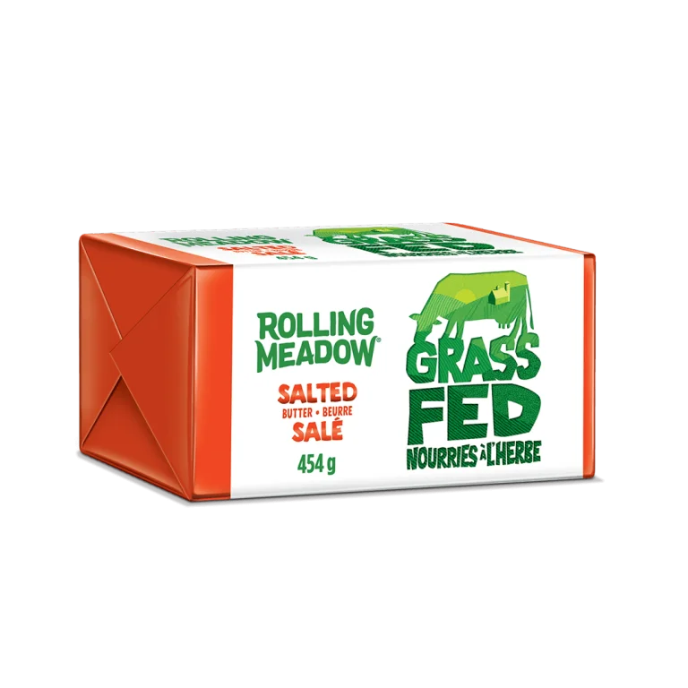 A package of Rolling Meadow Grass Fed Salted Butter, 454 g, shown on a clean white background. The packaging features a white front with green text and a green cow graphic, alongside orange side panels.
