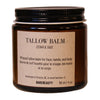 Tallow balm jar with label on a wooden block against a beige background