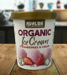 Avalon Organic Ice Cream container with strawberries and cream flavor on a wooden surface.