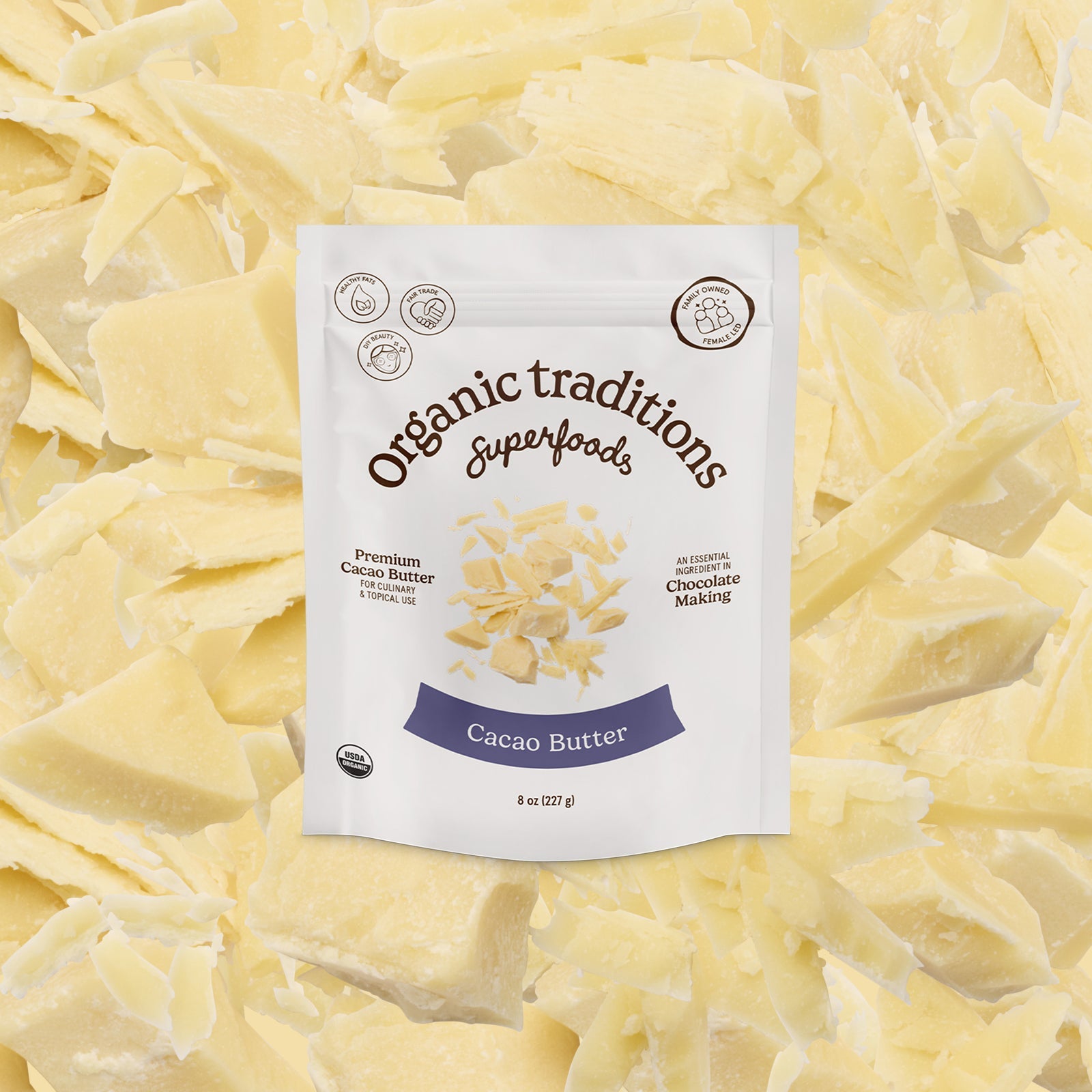 Package of Organic Traditions Cacao Butter on a bed of cacao butter flakes
