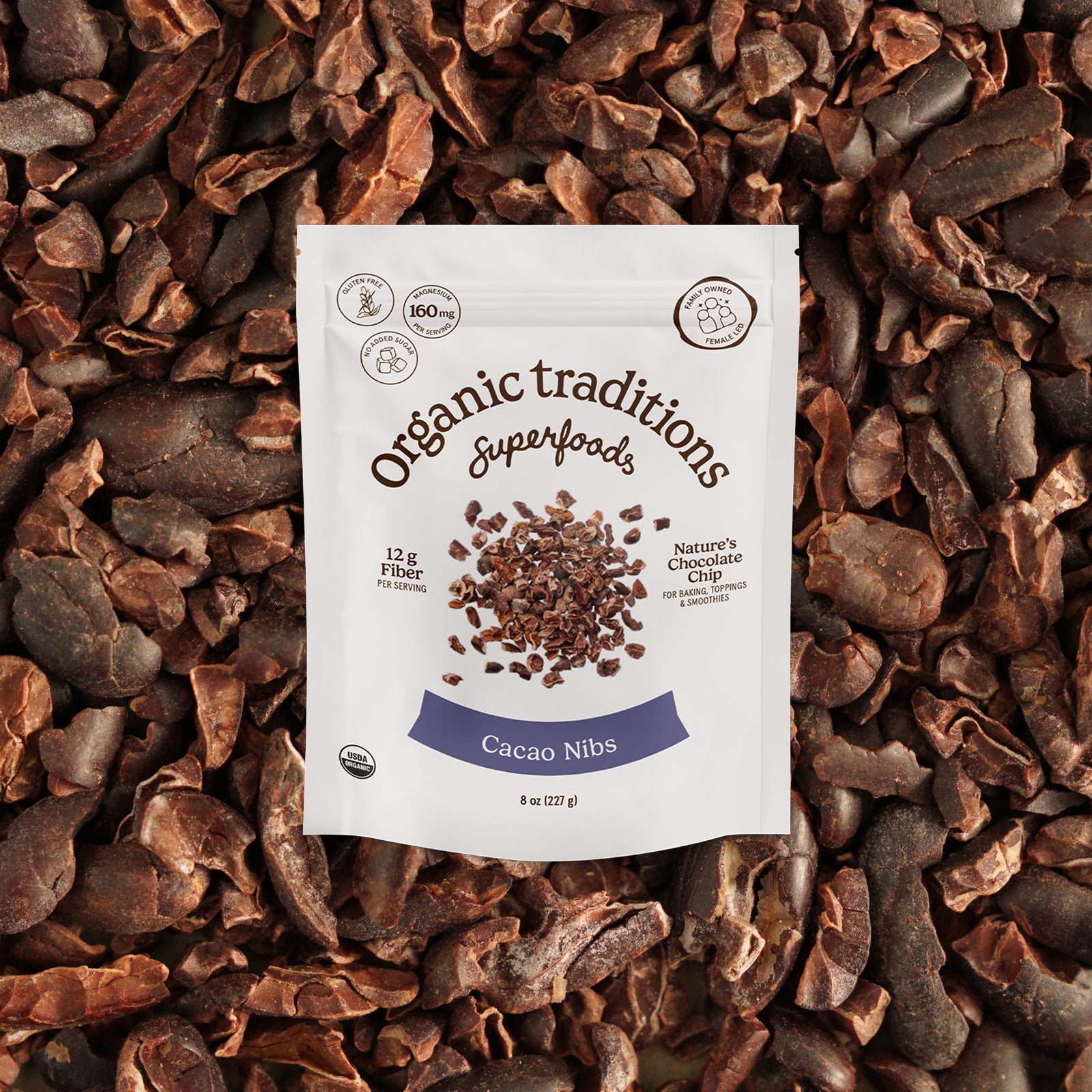 Cacao nibs package on a bed of cacao nibs with 'Organic Traditions Superfoods' branding.