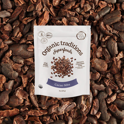 Cacao nibs package on a bed of cacao nibs with 'Organic Traditions Superfoods' branding.