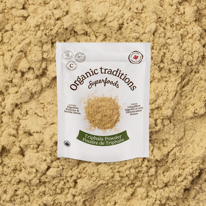 Package of Organic Traditions Triphala Powder on a bed of the powder