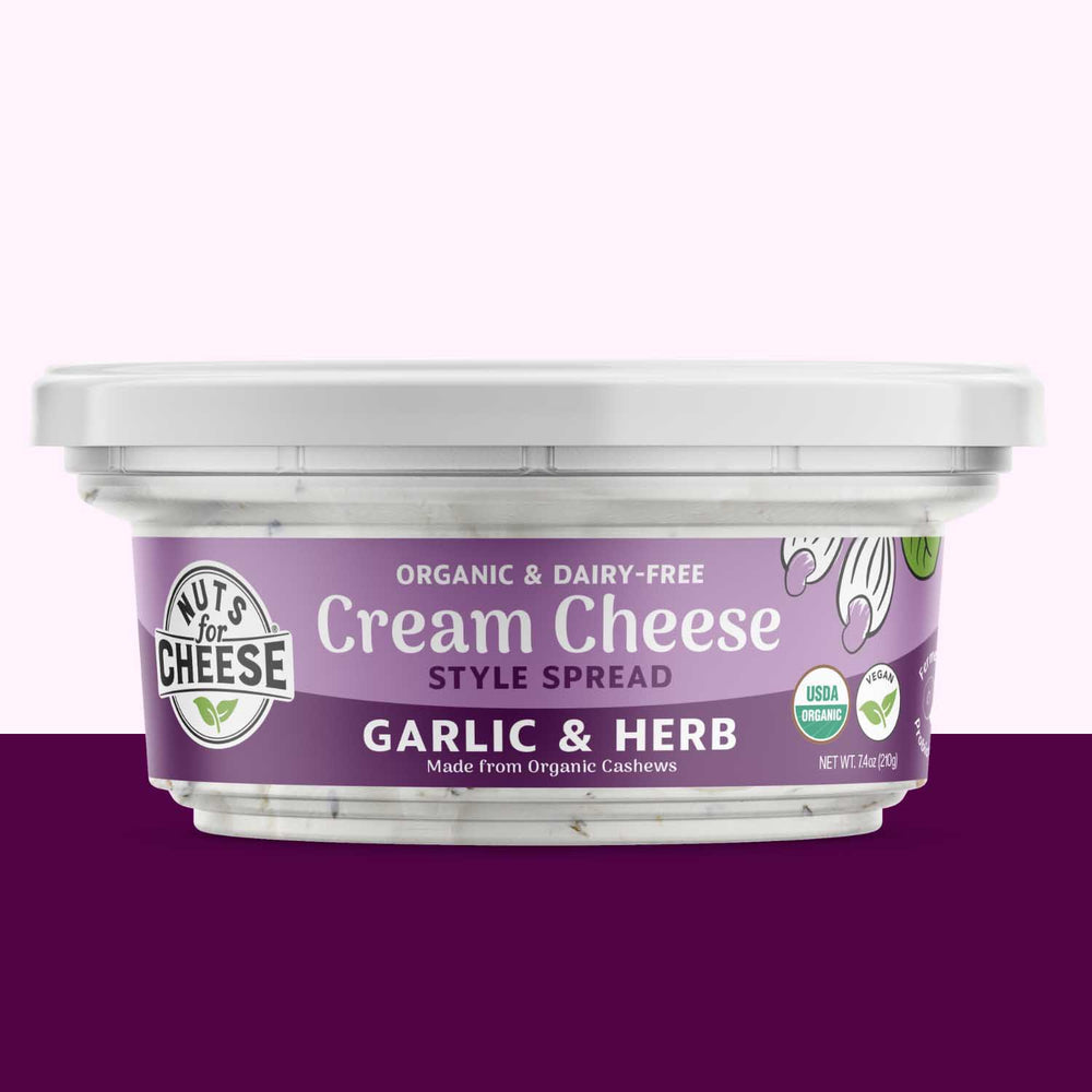 Container of garlic and herb cream cheese spread with a purple label on a white background