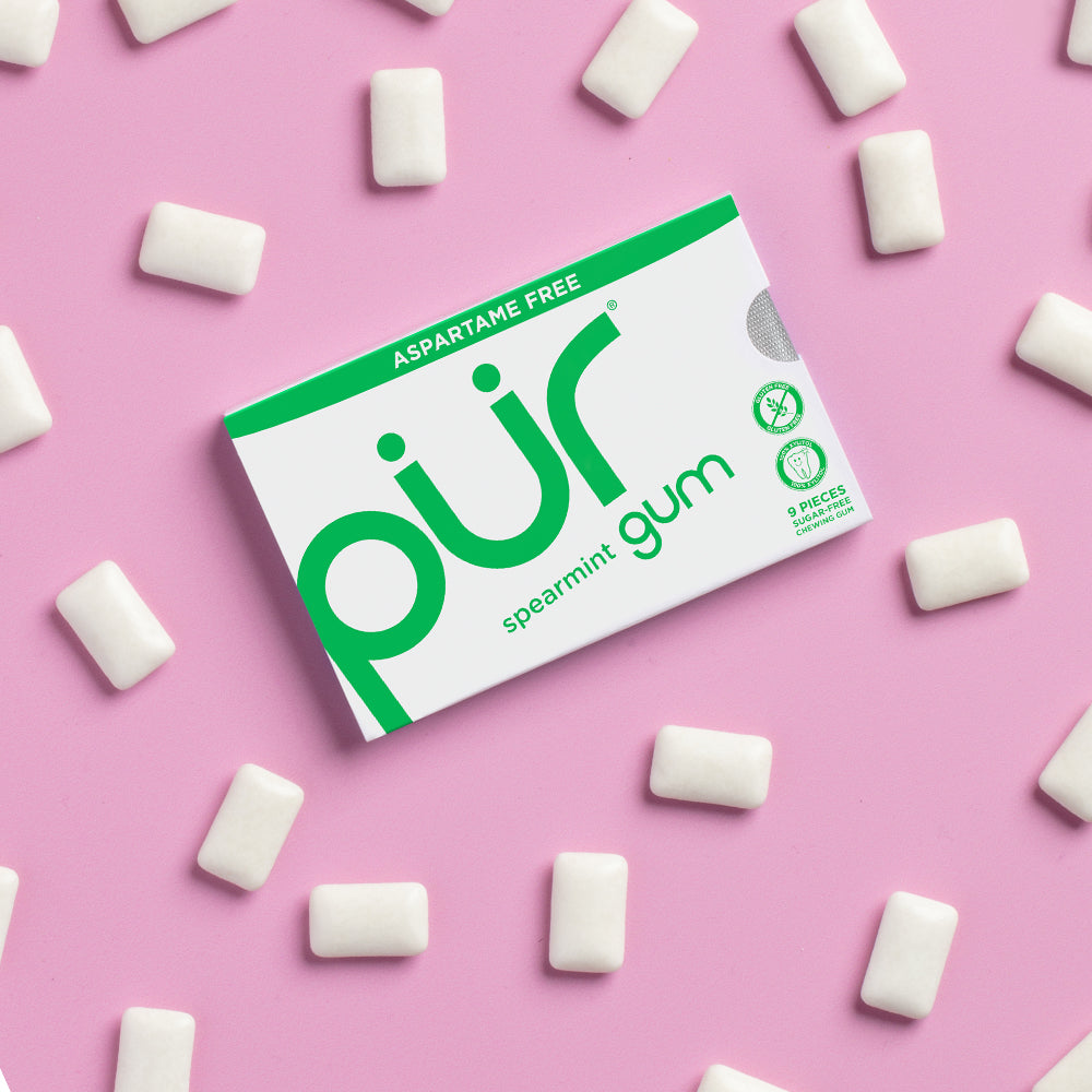Box of PUR gum with spearmint pieces on a pink background