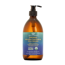 Bottle of organic golden castor oil with a pump on a gray background