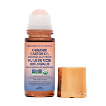 Organic castor oil bottle with rose quartz roller on a gray background