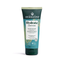 A tube of Herbatint Hydrate Conditioner with a green label, indicating it is enriched with 99% natural ingredients, dermatologically tested, and vegan-friendly.