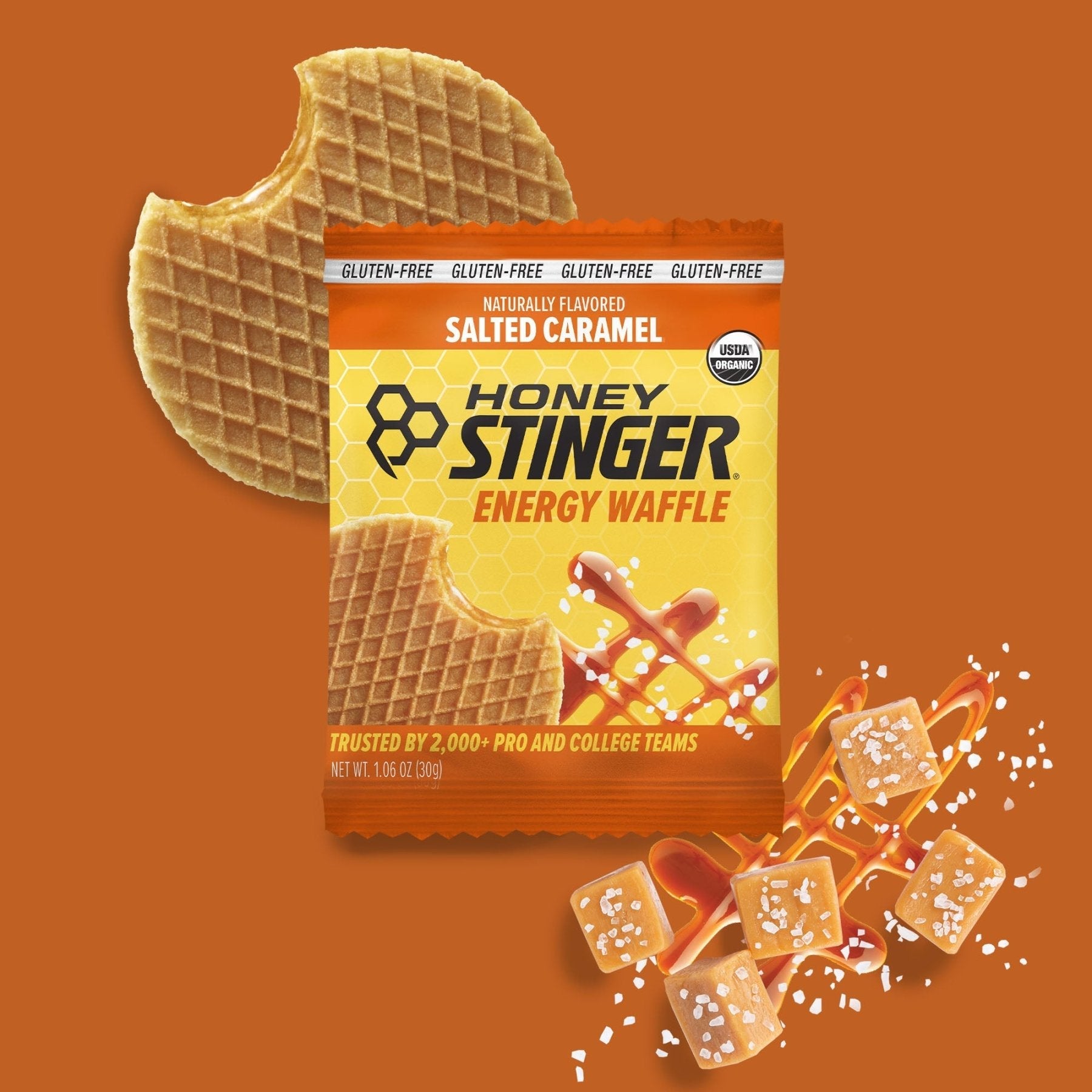 Honey Stinger Salted Caramel energy waffle package on an orange background